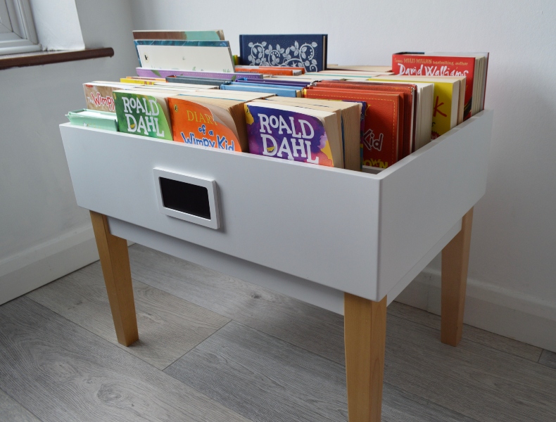 book storage landscape Mid-organisation of a kitchen cupboard, there are plates, bowls and other items on the kitchen counter below, as well as a large quantity of bottles on a cupboard shelf, an empty cupboard shelf, and a pile of miscellaneous containers on another cupboard shelf