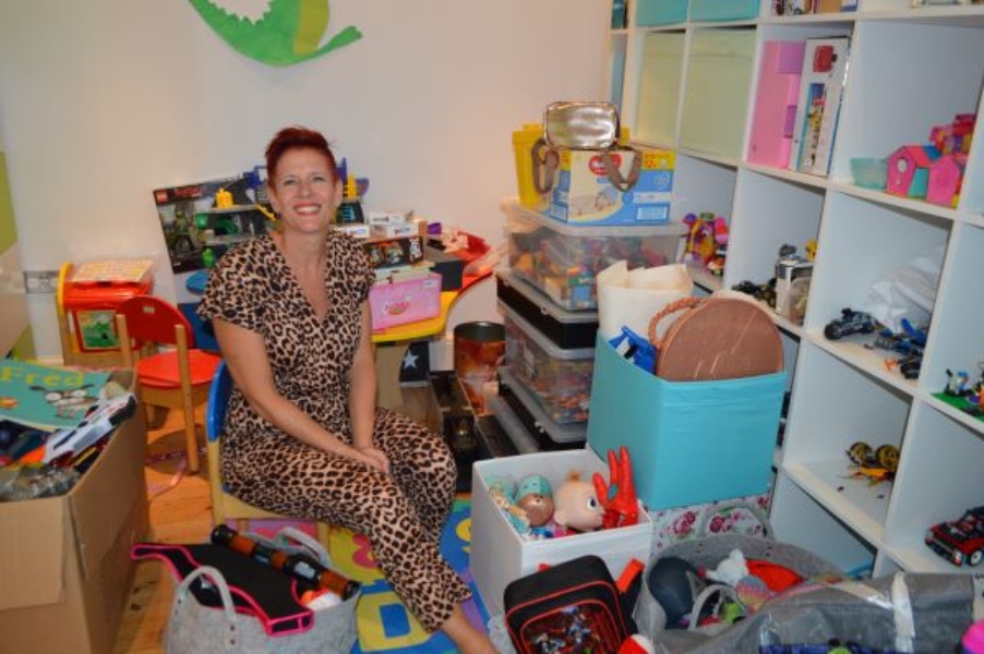 me in playroom landscape A kitchen cupboard with organised glassware by type, plates and bowls, as well as drinking bottles