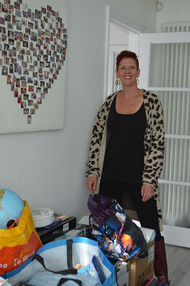 Roxy organising content into boxes, standing inside a room