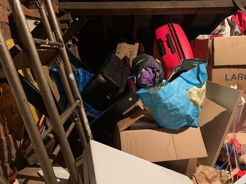 loft before 2 Original loft area, everything is piled on the floor, with boxes and items haphazardly strewn around. There is no space to walk across the space to reach anything at the far wall